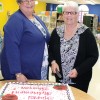 New head librarian Laurie Huestis and Sharon Edwards cut the retirement party cake.