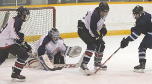 Fort Macleod Mavericks defenceman Cauy Yellow Face clears the puck from goalie Brody Zmurchyk's crease. 