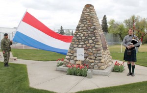 Lieut. Werner Dressler of the 2309 Fort Macleod Army Cadets holds the Dutch flag as the piper plays.