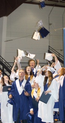Members of the Class of 2016 toss their mortarboard caps into the air at the conclusion of the cap and gown ceremony.
