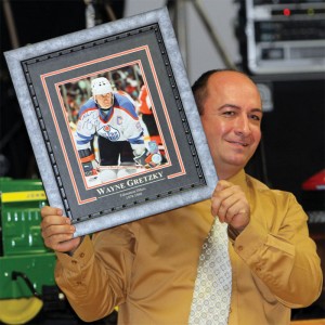Brian Vandervalk displays a framed, autographed photo of hockey star Wayne Gretzky.auction.