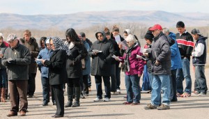 Way of the Cross participants stand for a reading at one of the Stations of the Cross.