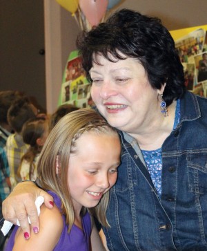 Retiring teacher Lori Filatoff gets a hug from one of the students.