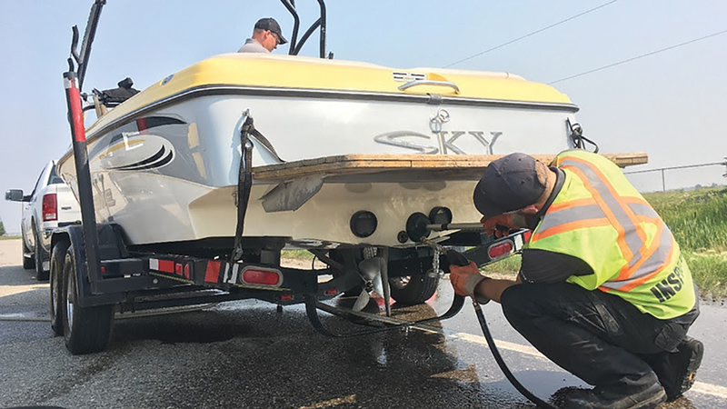 Inspectors decontaminate a boat