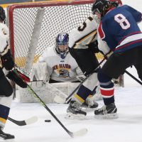Kaleb Doyle (8) of the Fort Macleod Mavericks battles for the puck in front of Havre Ice Hawks goalie Sean Nagel.