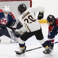 Kenton Larson of the Havre Ice Hawks gets a shot on Fort Macleod Mavericks goalie Owen Archibald, with Kylan Blackwater defending.