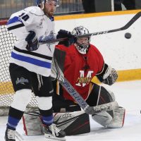 Dayn Opel of the Lethbridge Lightning tries to deflect a high shot in front of Fort Macleod Mustangs goalie Aaron DeKok.