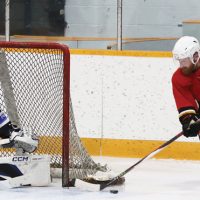 Jadon Porterfield of the Fort Macleod Mustangs attempts a wrap-around against Lethbridge Lightning goalie Aidan Low.