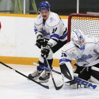 A scoring attempt by Peyton White Quills of the Mustangs is stopped by Lethbridge Lightning goalie Aidan Low and defenceman Jalen Twigg.