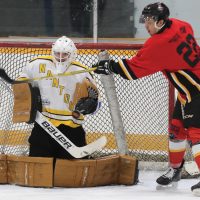 Dalton Eagle Bear of the Fort Macleod Mustangs tries to deflect the puck past Nanton Palominos goalie Matthew McDonald.