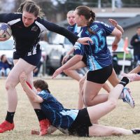 Katharina Stinsky of the F.P. Walshe Flyers runs through an attempted Matthew Halton Hawk tackle.