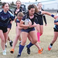 Neveyah Fox of the F.P. Walshe Flyers is wrapped up by a Matthew Halton Hawk with teammates Aby McClung and Lux Prince in the background